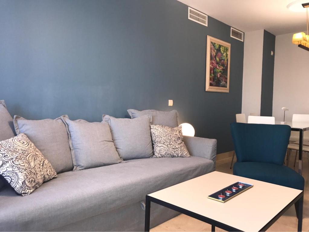 a living room with a couch and a table at Apartamento Paseo Marítimo Antonio Banderas in Málaga