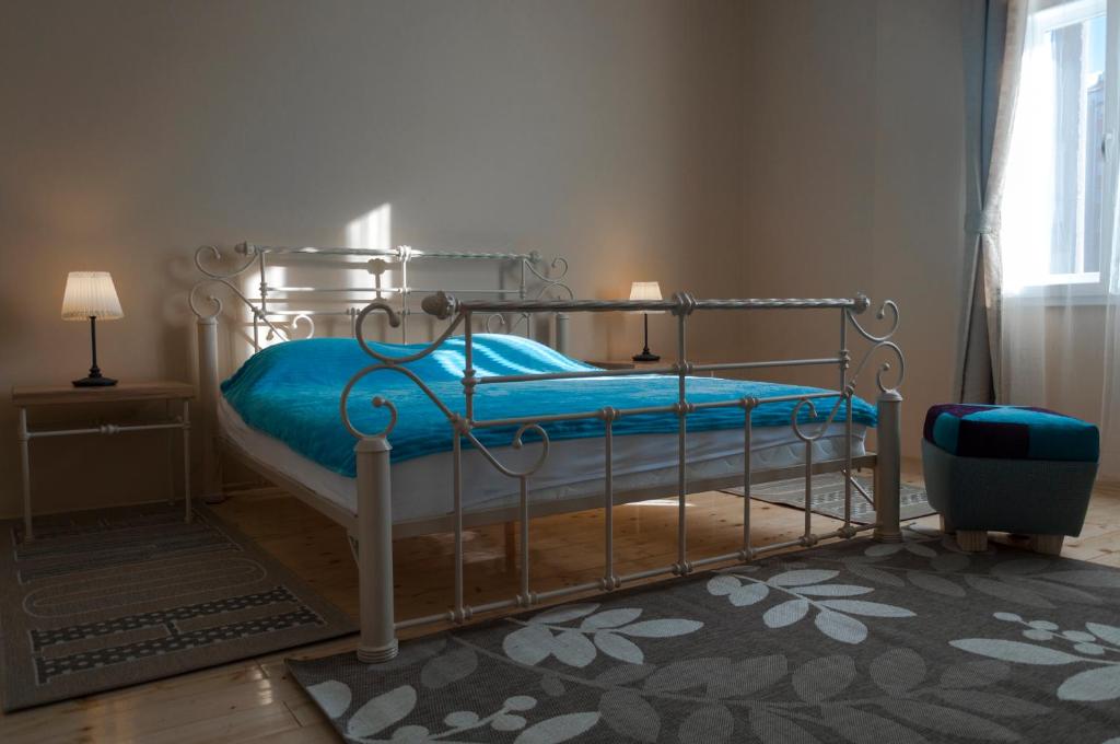 Schlafzimmer mit einem Bett mit blauer Bettwäsche und einem Fenster in der Unterkunft Apartment By the River in Niš