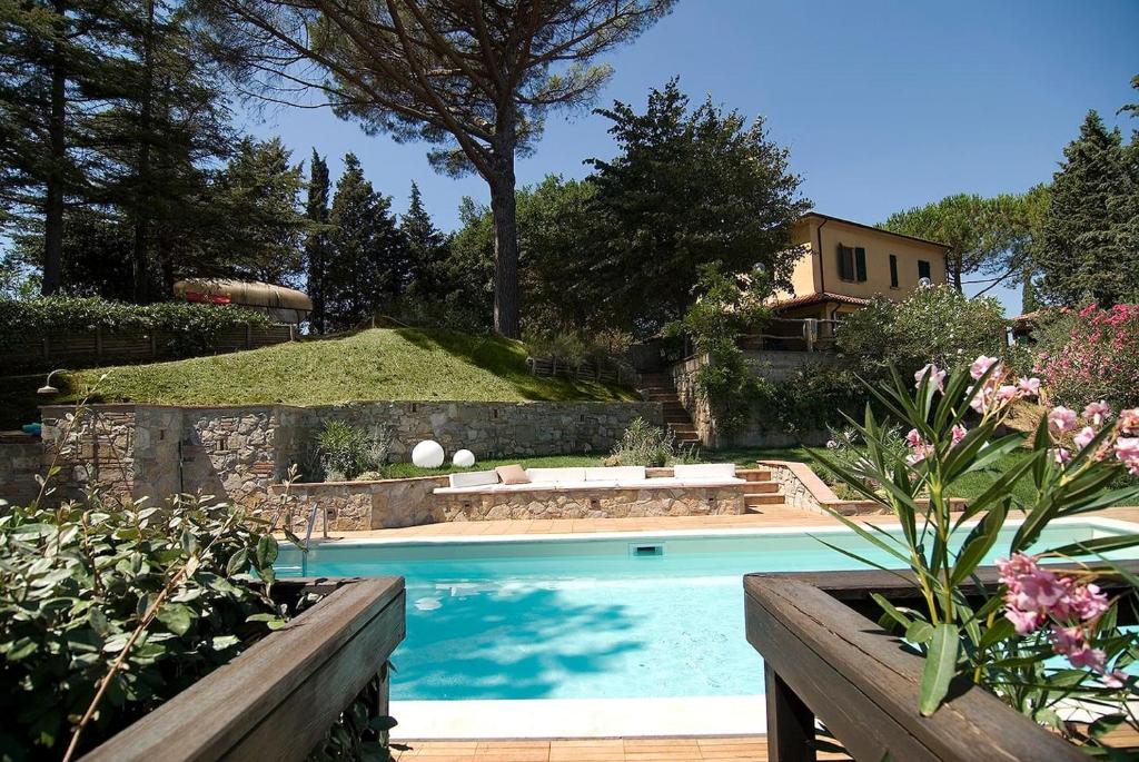 een zwembad in een tuin met een huis bij Stunning Country House overlooking Tuscany hills in Lorenzana