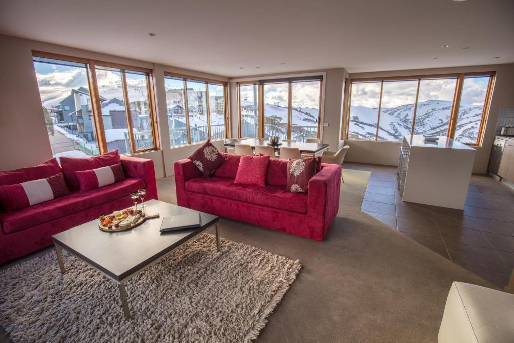 una sala de estar con 2 sofás rojos y una mesa. en Absollut, en Monte Hotham