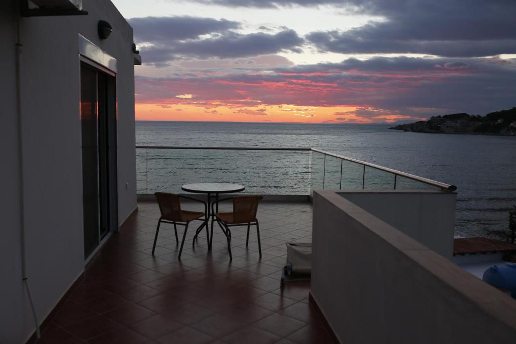 balcón con mesa, sillas y vistas al océano en Casa Mila apartments & bungalows en Ulcinj