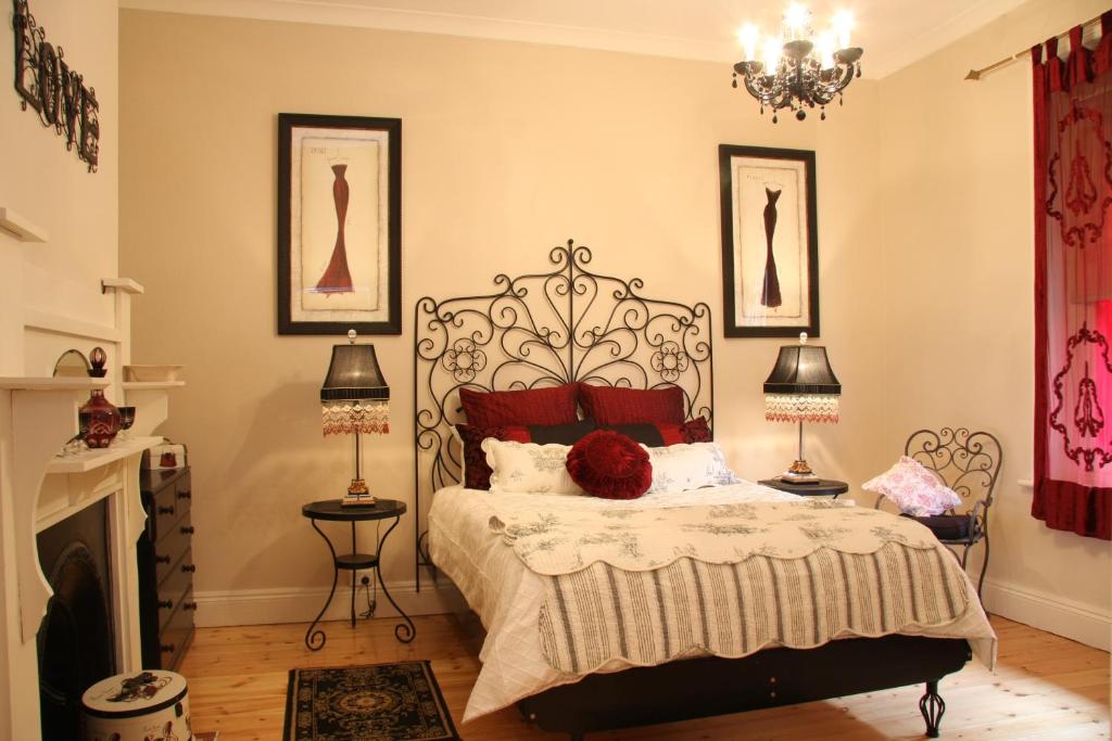 sypialnia z łóżkiem, 2 lampami i kominkiem w obiekcie Azalea Cedar-Rose Barossa Valley Villa w mieście Lyndoch