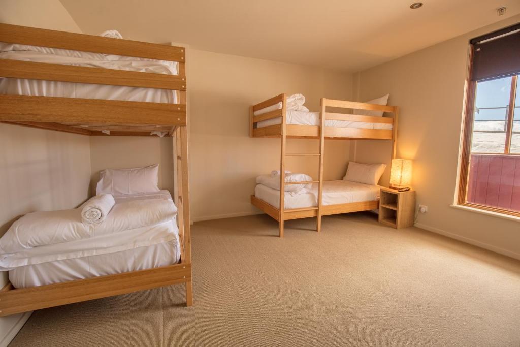 a bedroom with two bunk beds and a window at Sambuca in Mount Hotham
