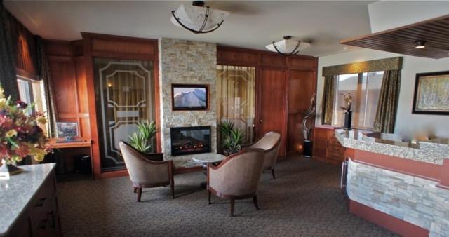a lobby with chairs and a fireplace in a room at Motel Du Chevalier in Gatineau