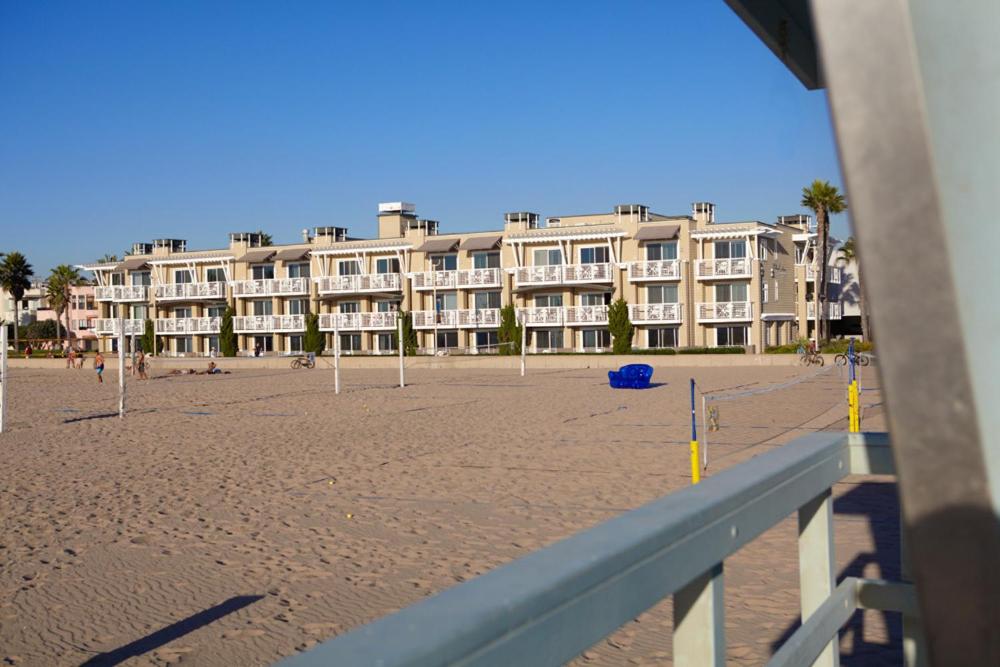 Beach House Hotel at Hermosa Beach في هيرموسا بيتش: اطلالة على شاطئ مع مبنى كبير