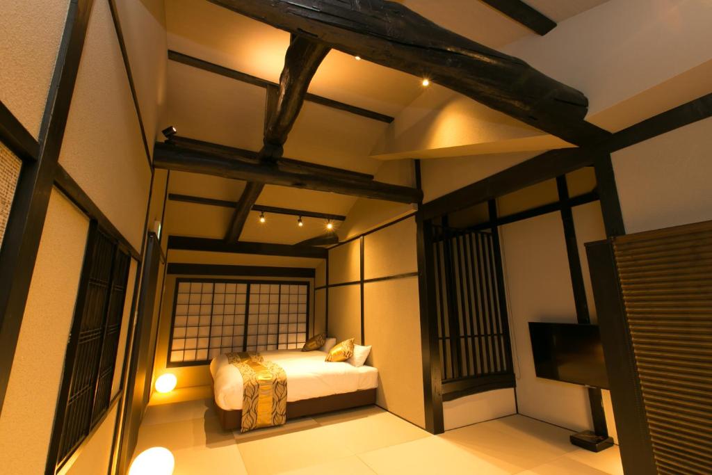 ein Schlafzimmer mit einem Bett und einem TV in einem Zimmer in der Unterkunft Hosta Umekoji Akari in Kyoto