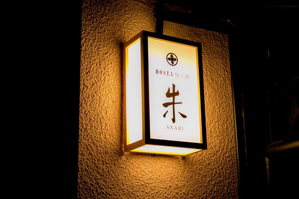 a light on a wall with a sign on it at Hosta Umekoji Akari in Kyoto