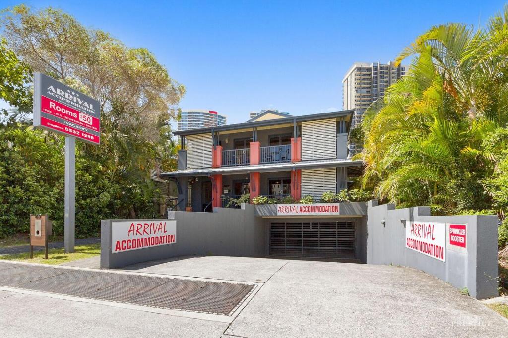 a house with a sign in front of it at Arrival Lodge Hostel Accommodation in Gold Coast