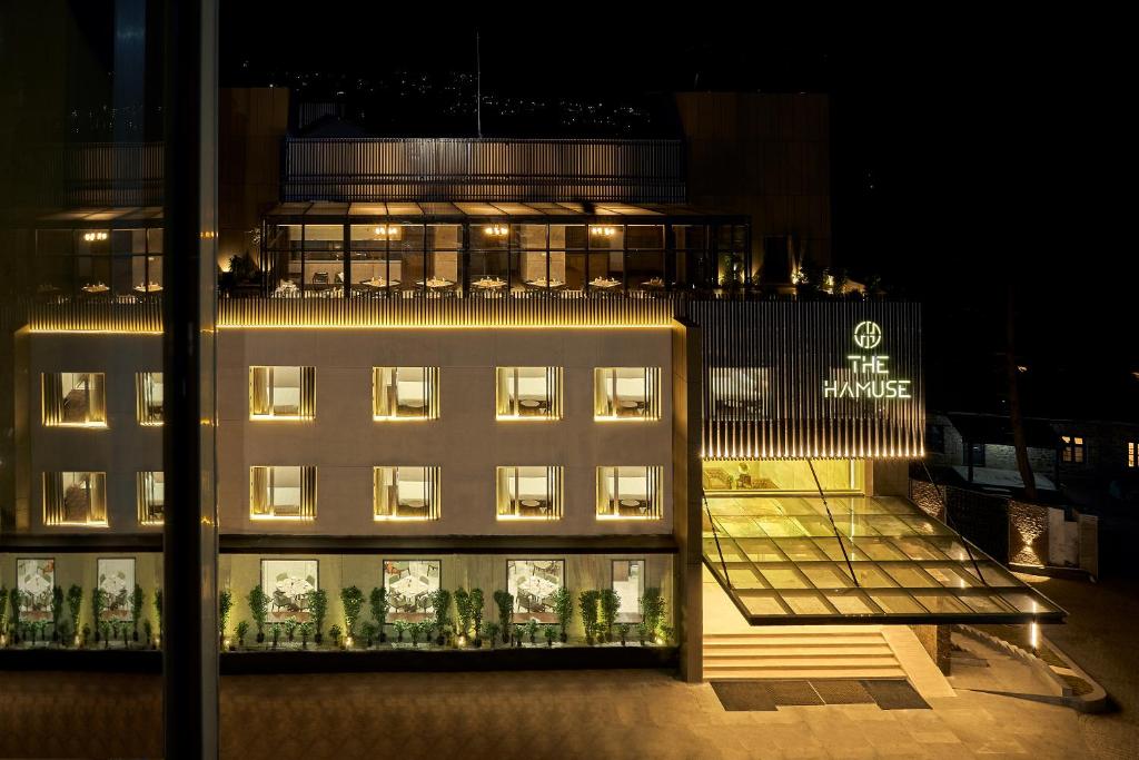 een verlicht gebouw met een gebouw met verlichting bij The Hamuse Luxury hotel in Kodaikānāl