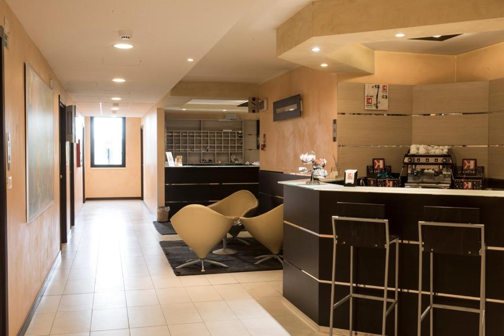 eine Küche mit einer Bar und Hockern in einem Zimmer in der Unterkunft Hotel Corte Business in Cavriago
