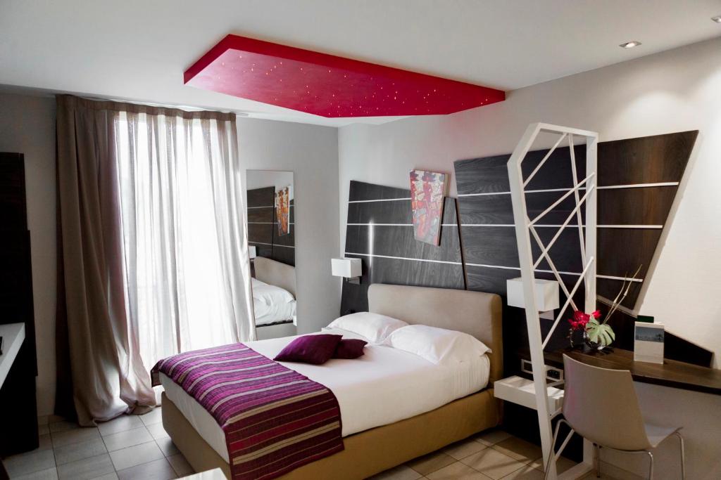 a bedroom with a bed with a red ceiling at Hotel Villa d'Elsa in Juan-les-Pins