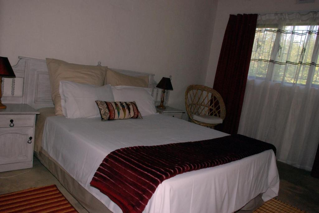 - une chambre avec un lit, une chaise et une fenêtre dans l'établissement Toad Tree Cabins, à Sodwana Bay