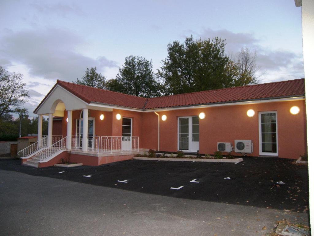 a small orange house with a parking lot at Hostellerie Del Matin Calme in Montverdun
