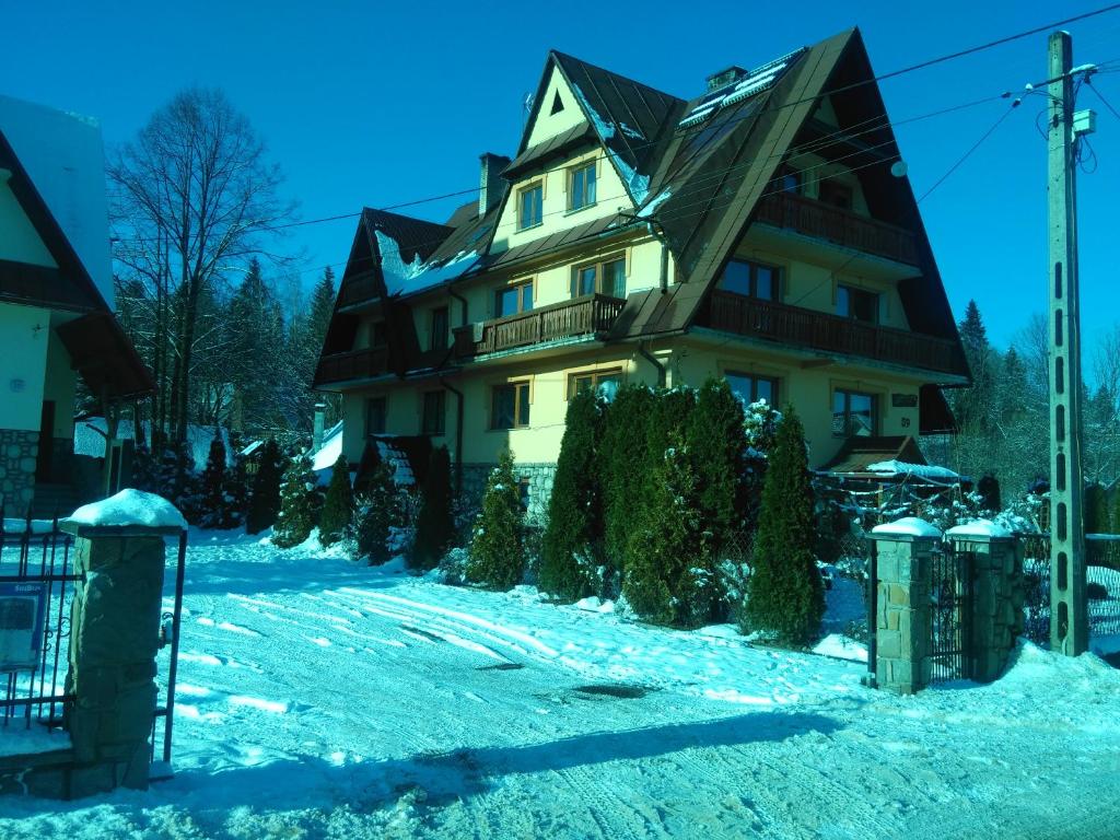 Una casa en la nieve con árboles de Navidad en U Dany, en Białka Tatrzanska