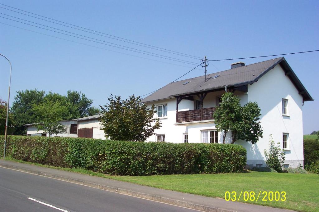 Ein weißes Haus an der Seite einer Straße in der Unterkunft Urlaub auf dem Bauernhof Marx in Kelberg