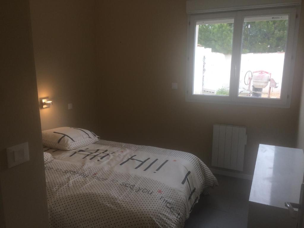 a bedroom with a bed with two pillows and a window at Maison indépendante in Marseille