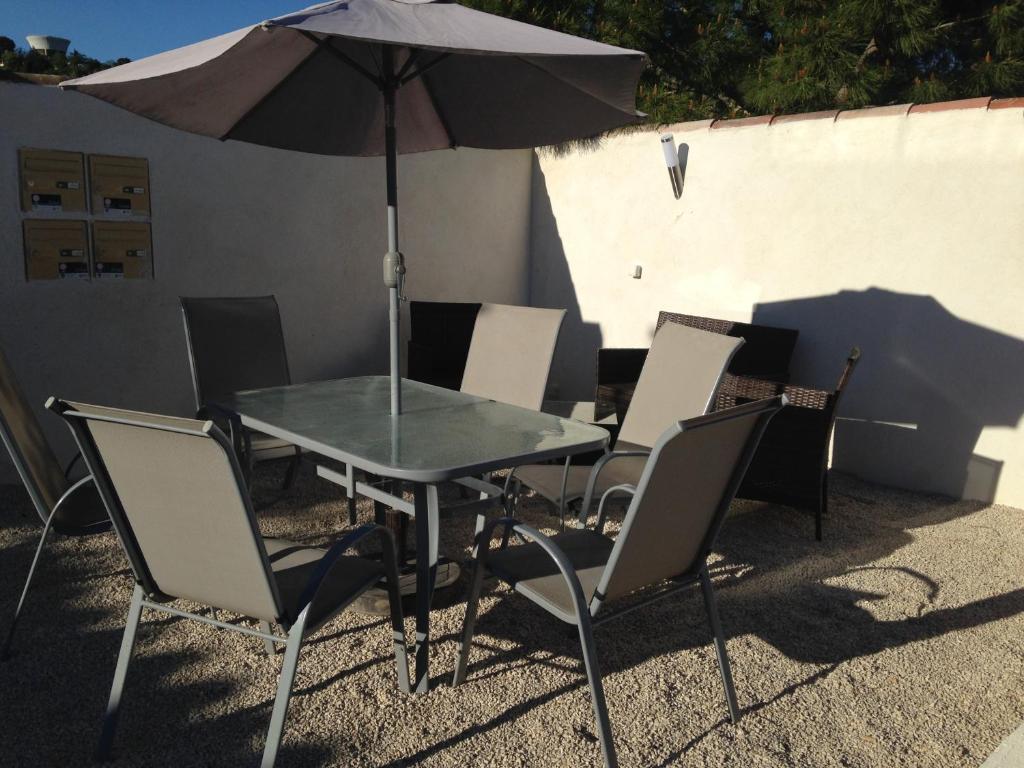 a table and chairs with an umbrella on a patio at Maison indépendante in Marseille