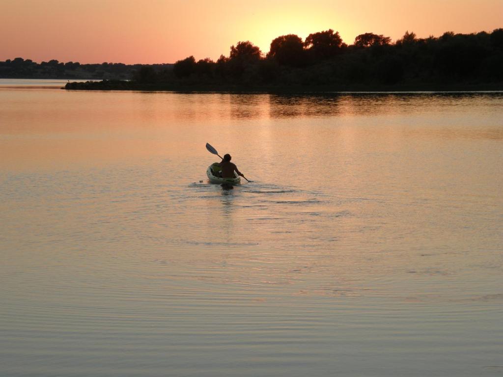 uma pessoa num caiaque num lago ao pôr-do-sol em Casa da Ermida de Santa Catarina em Santa Eulália