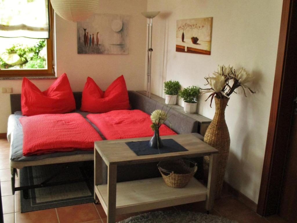 a bedroom with a bed with red pillows and a table at Haus Inge in Sankt Gallenkirch