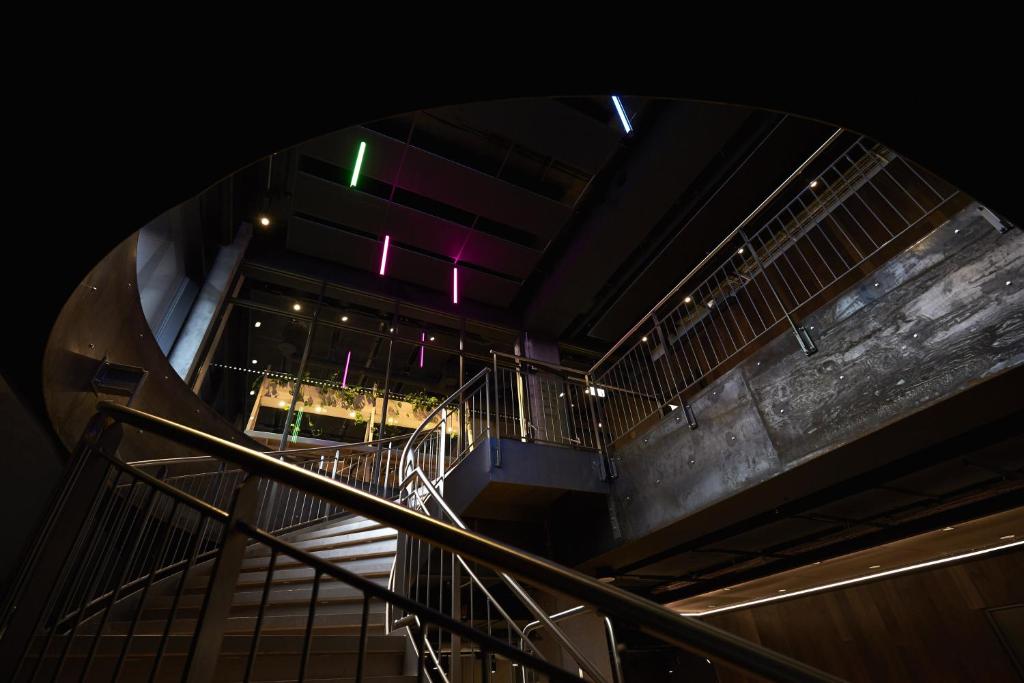 a spiral staircase in a building with lights at Steel House Copenhagen in Copenhagen