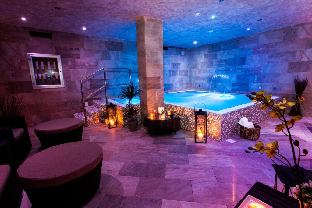 un spa con bañera en una habitación con luces en Hotel Costazzurra Museum & Spa, en San Leone