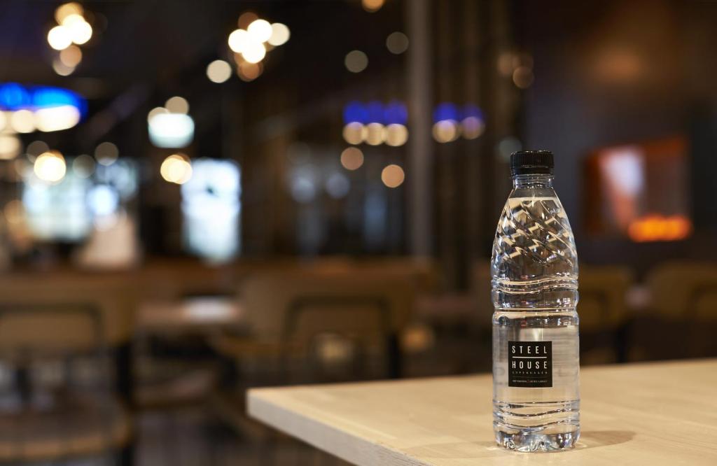 a bottle of water sitting on top of a table at Steel House Copenhagen in Copenhagen