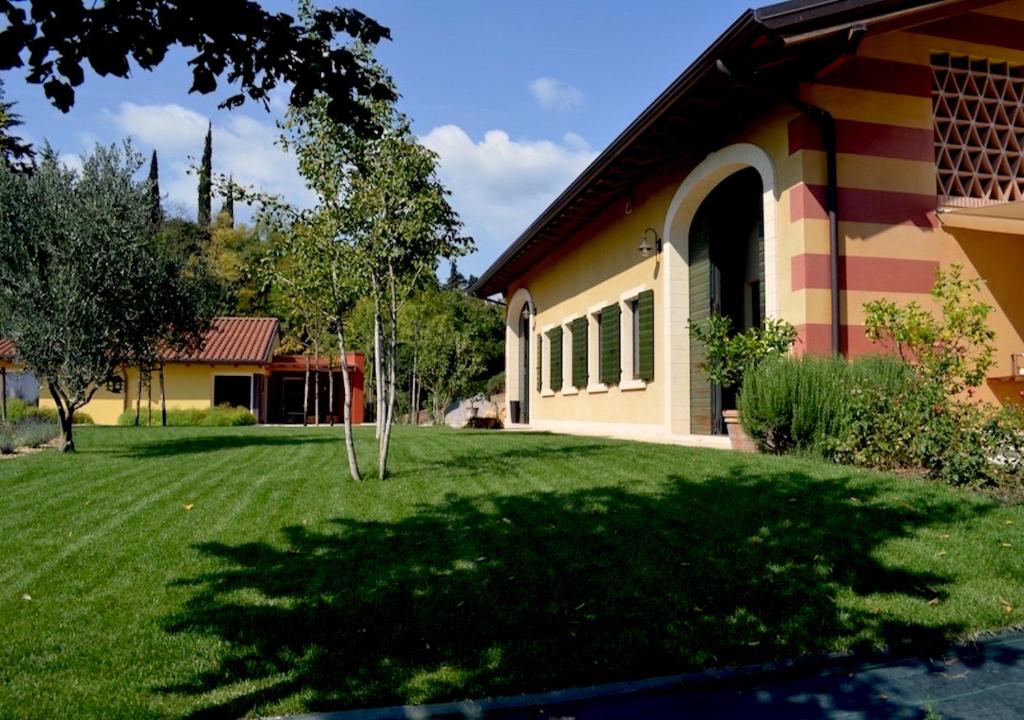 uma casa com um pátio verde ao lado de um edifício em Agriturismo Sommavalle em Verona