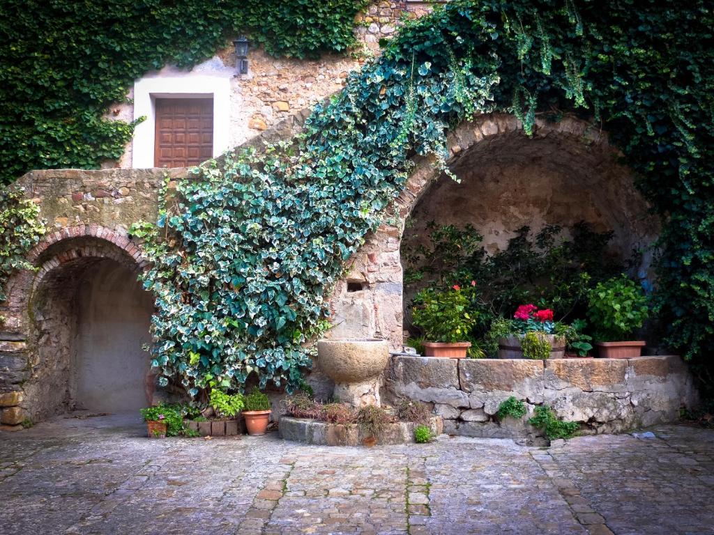 an ivy covered building with potted plants on it at Baglio Bonomo in Castelbuono