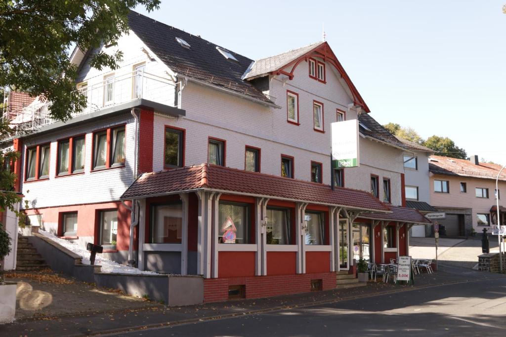 un bâtiment rouge et blanc avec un magasin dans l'établissement Hotel Ristorante Ätna, à Ulrichstein