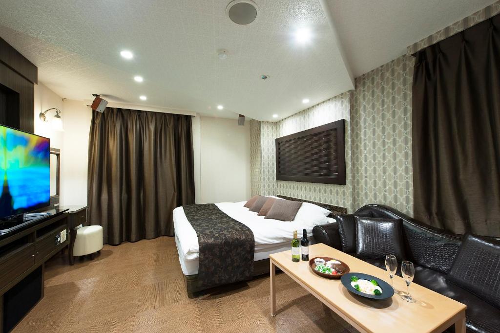 ein Hotelzimmer mit einem Bett und einem TV in der Unterkunft Gifu Mine(Adult Only) in Ginan