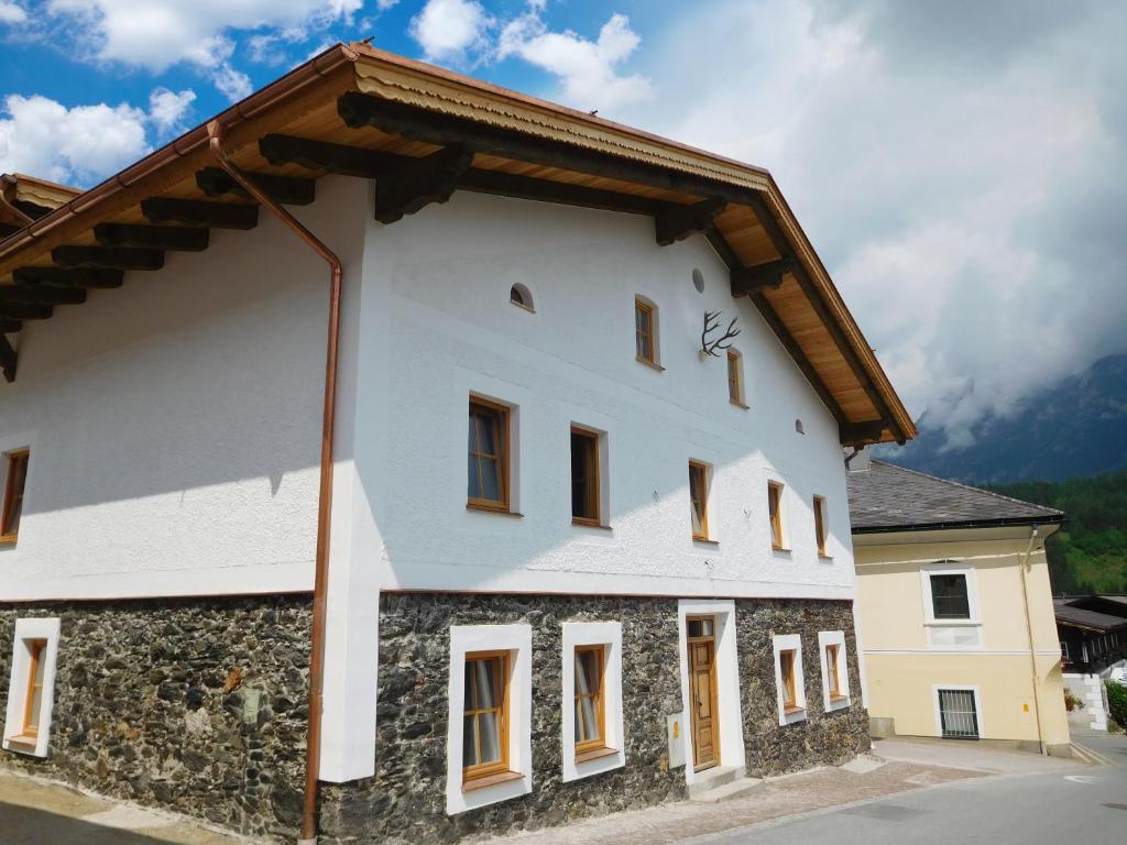 a white building with a brown roof at Appartements Kornberg Gütl in Haus im Ennstal