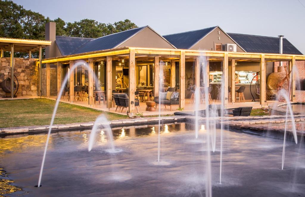 a building with water fountains in front of it at Botlierskop The Village Lodge in Great Brak River