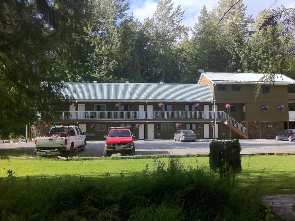 un gran edificio con coches estacionados frente a él en The Hitching Post Motel en Pemberton