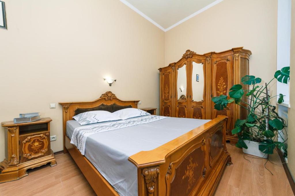 キーウにあるApartment in Kostelna srtのベッドルーム1室(木製ベッド1台、木製ドレッサー付)
