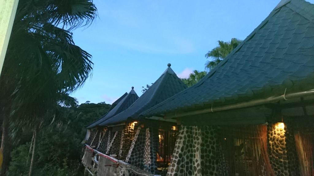 a building with a roof with lights on it at In Bali Inn in Luofu