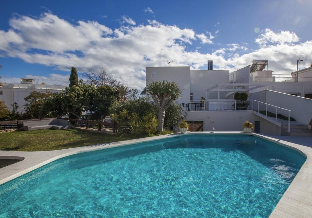 a swimming pool in front of a house at Villa Carabeo San Salvador Nerja in Nerja