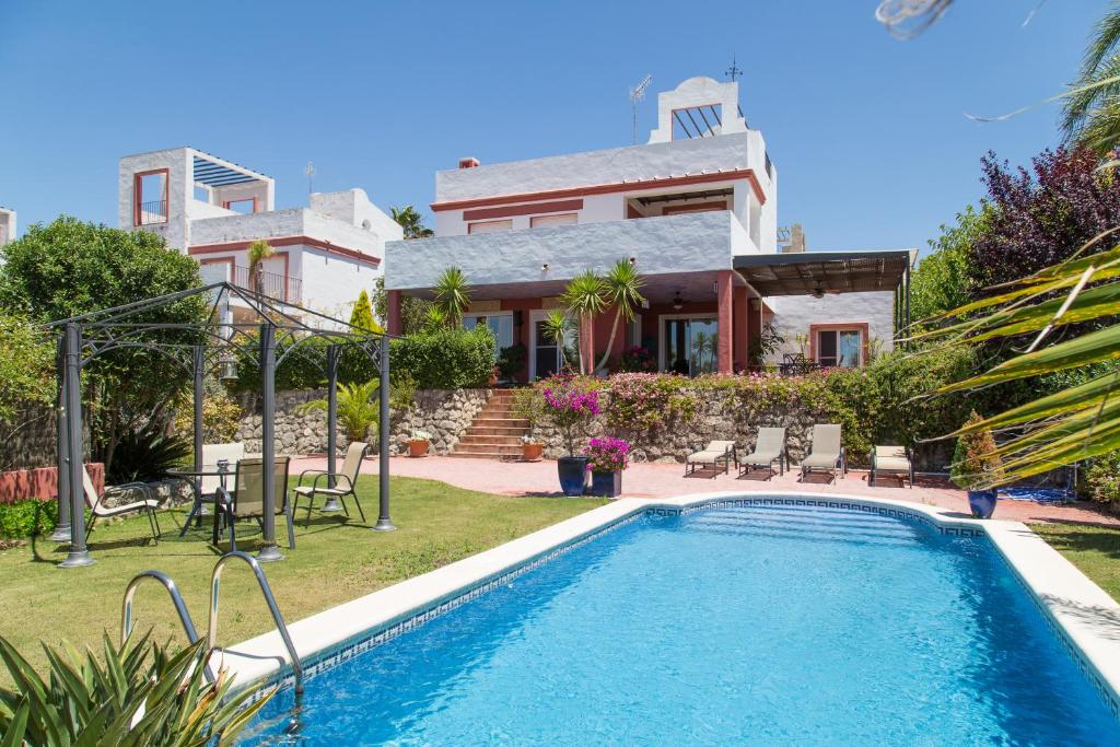 サンルーカル・デ・バラメダにあるPreciosa villa de lujoの家の前にスイミングプールがある家