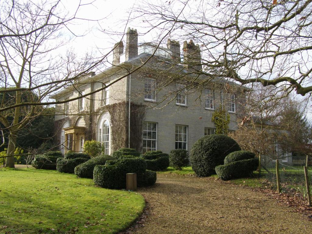 una casa grande con arbustos delante en The Lynch Country House, en Somerton