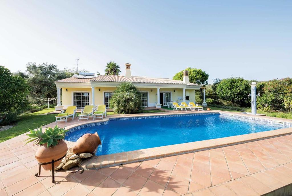 eine Villa mit einem Pool vor einem Haus in der Unterkunft Los Olivos Lea in Boliqueime
