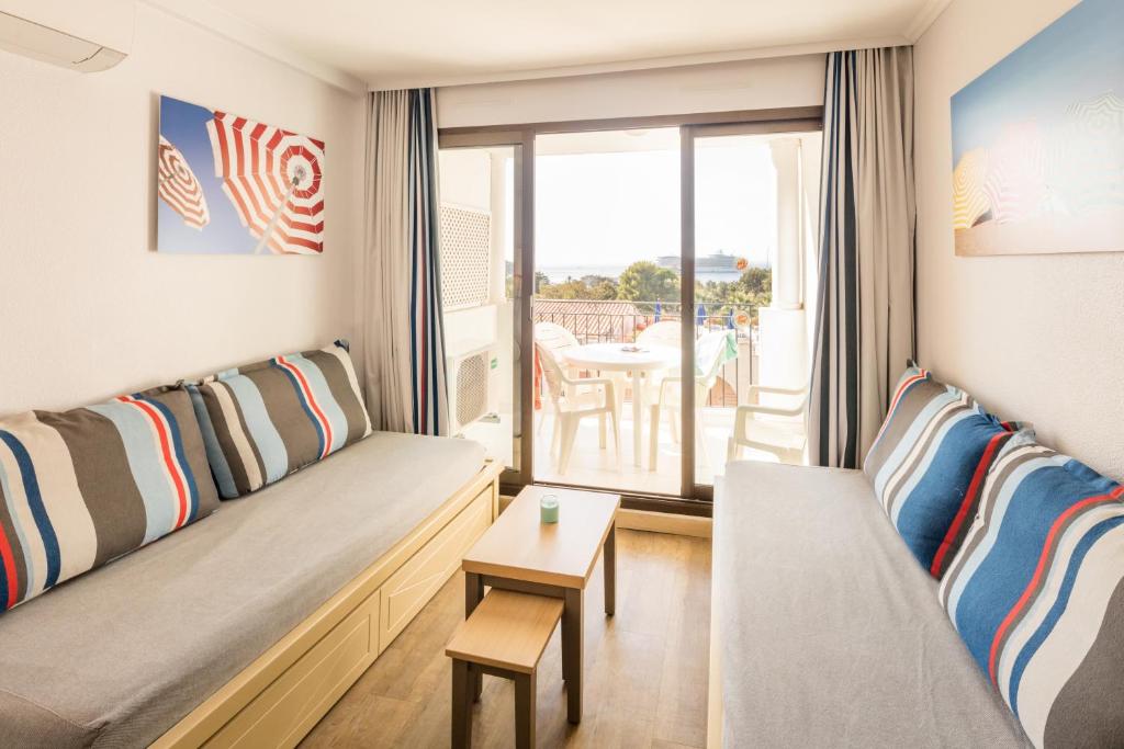 a living room with a couch and a table at Résidence Pierre & Vacances l'Ange Gardien in Villefranche-sur-Mer