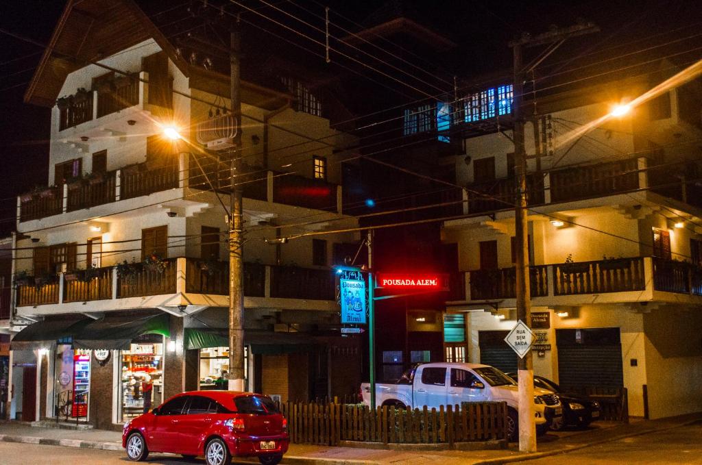 a red car parked in front of a building at night at Pousada Alemã in Santo Antônio do Pinhal