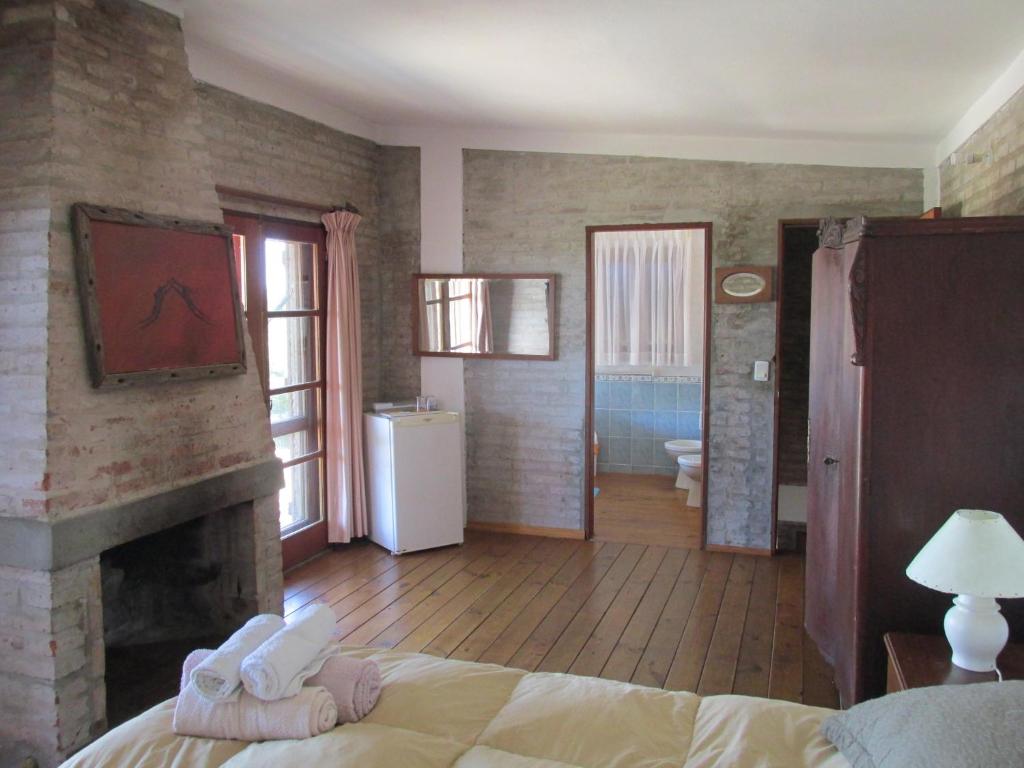 a bedroom with a fireplace and a bed and a bathroom at Je Nous Casa in José Ignacio