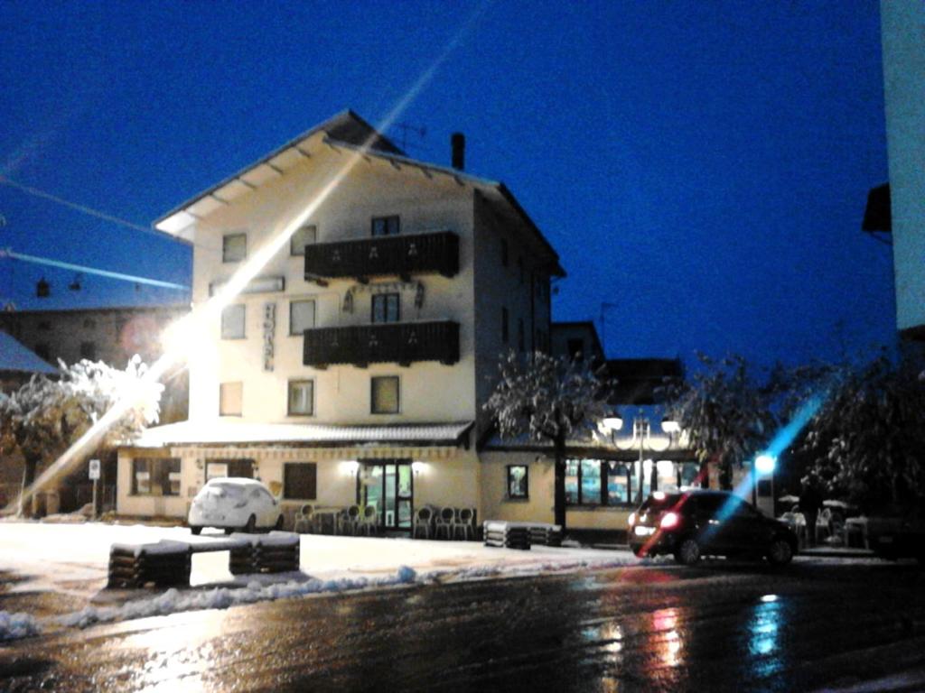 un bâtiment avec une voiture garée devant lui la nuit dans l'établissement Hotel Capriolo, à Vidiciatico
