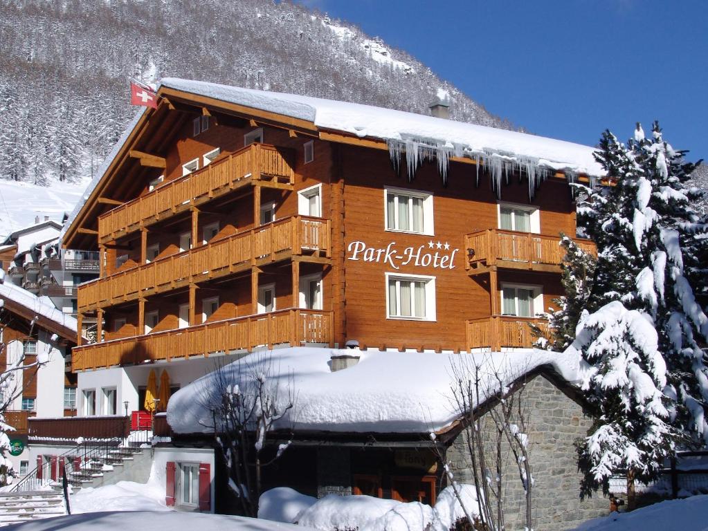 a large wooden building with snow on it at Park-Hotel Saas- Fee in Saas-Fee