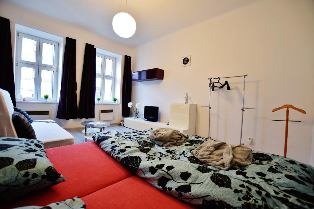 - une chambre avec un lit et une couverture dans l'établissement Apartmán Hybešova, à Brno