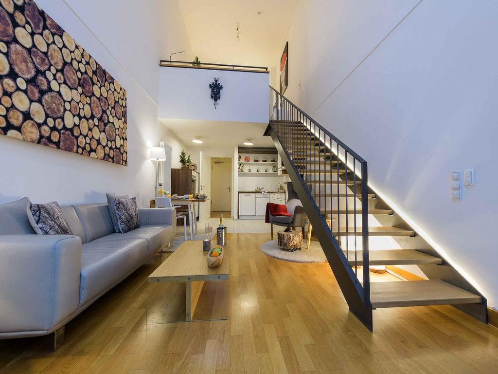a living room with a couch and a staircase at Schwarzwald Loft in Baden-Baden