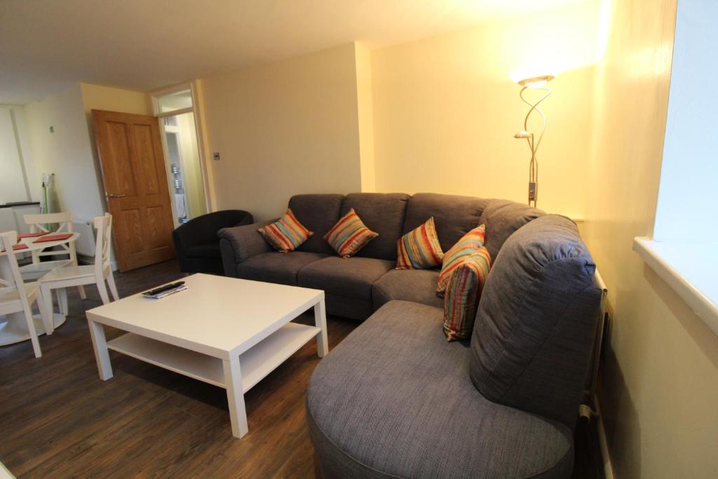 een woonkamer met een bank en een tafel bij The Little Maryville - City Centre - Parking - 2BR in Belfast