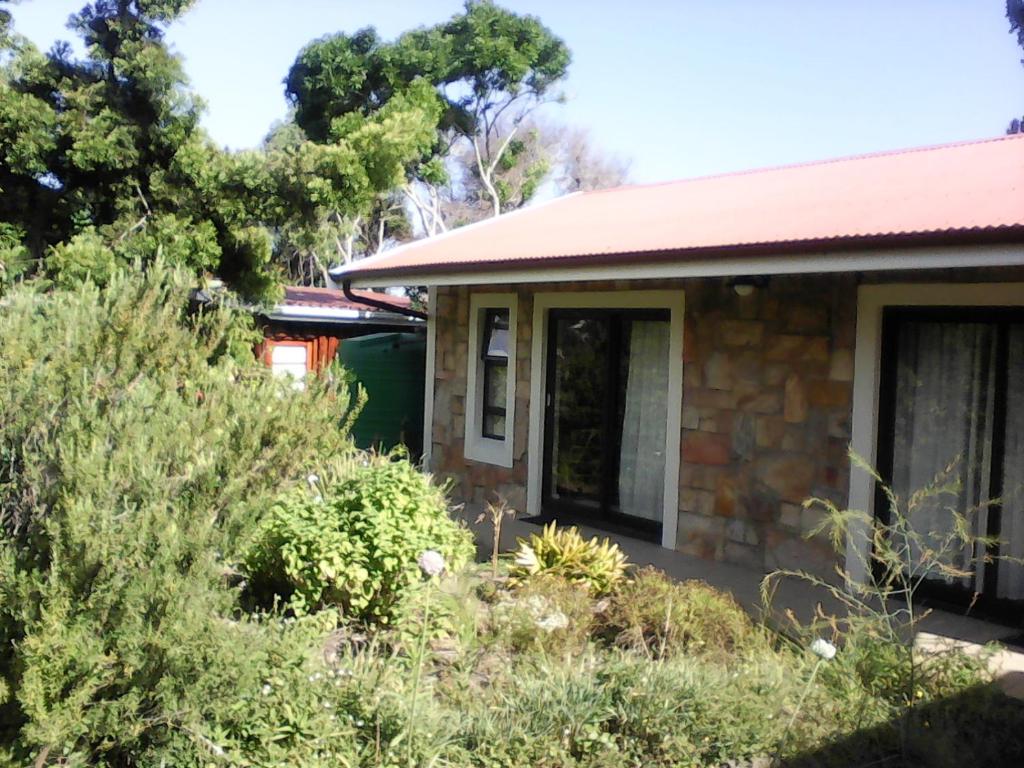 une maison avec des plantes devant elle dans l'établissement Forest Cove cottage, à Knysna