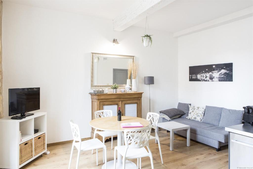 un salon avec un canapé, une table et des chaises dans l'établissement Augustins -Petit cocon calme et lumineux avec parking, à Bordeaux