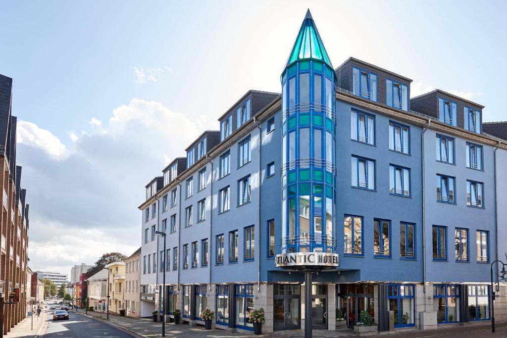 un edificio azul con una torre en una calle en Atlantic Hotel Vegesack en Bremen-Vegesack